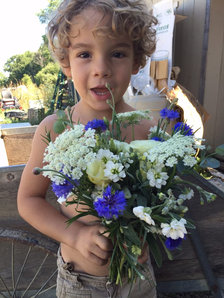 Silas, age 4, helps his mom model a beautiful bouquet. Photo by Trilby Becker.
