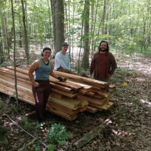 Ally, Chris, and Kyler stand by lumber for Shatter boardwalk