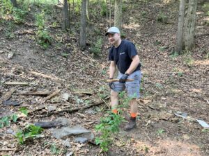 A volunteer removes debris from the old cabin site