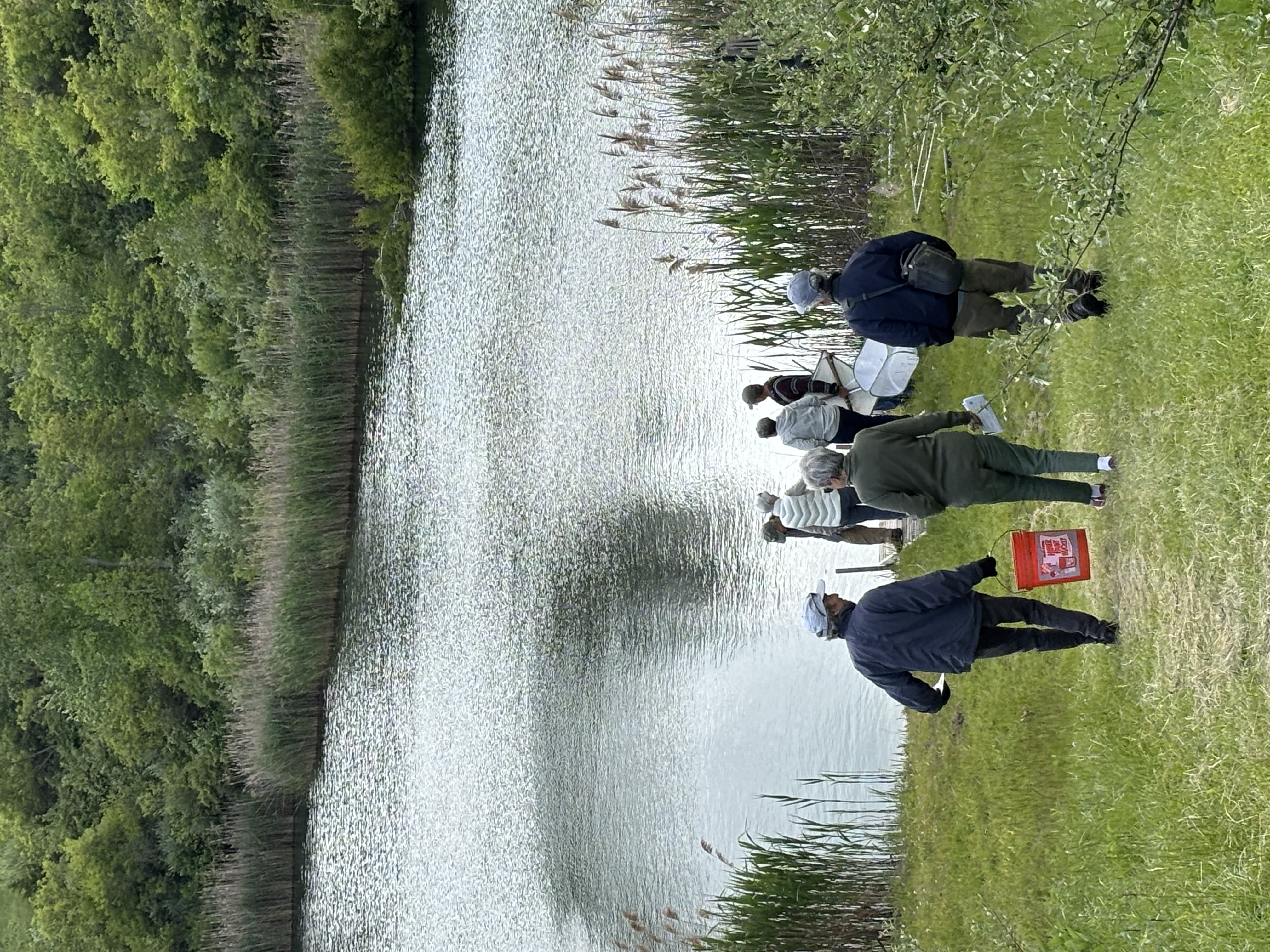 Group of people walking down a trail to a body of water