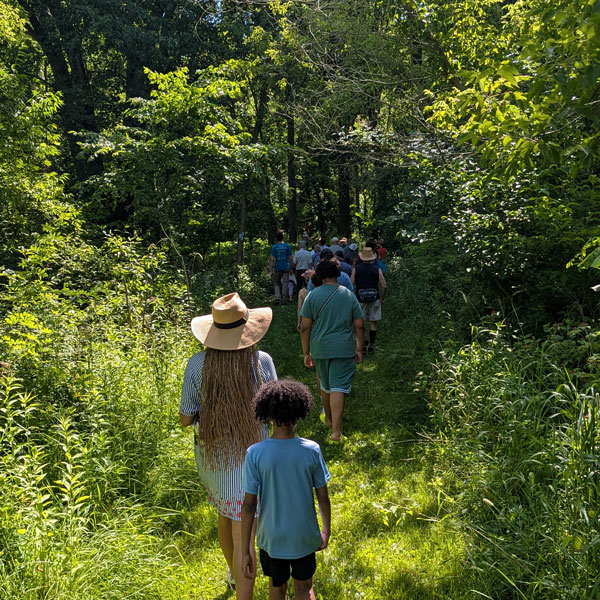 group of people walking into the woods at Iron Creek Nature Preserve